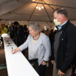 a person signs a steel beam for the student center at The College of ۿ۴ý