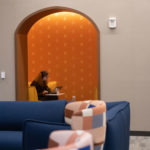 A student doing schoolwork in a yellow theme lounge on the second floor of Lowry Center at The College of ۿ۴ý.